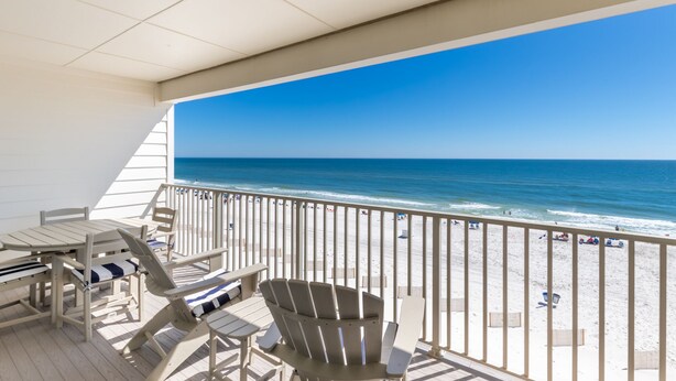 A balcony with a view of the beach, featuring a table and chairs. - Sea Glass 406 by Liquid Life (Gulf Shores)