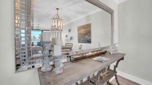 Una consola de madera con un espejo grande, velas y objetos decorativos.