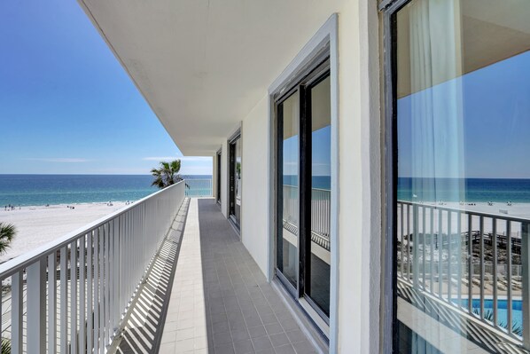 Un balcon avec vue sur la plage et l’océan.