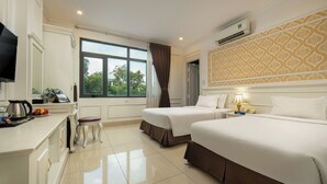 A hotel room with two beds, a desk with a coffee maker, a TV, and a window with curtains. - Toan Thang Hotel by Bay Luxury (Hanoi)