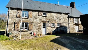 A stone house with a sloped roof, wooden shutters, and a chimney. - Cosy rural 5 bedroom home with games room, pet friendly, garden, bbq! (Ger)