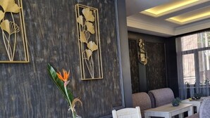 A modern lounge area with a marble floor, white furniture, and decorative wall art. - Days Inn Hotel (Yerevan)