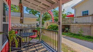 A covered outdoor patio with a grill, seating area, and a view of neighboring houses. - N39 Ocean Lakes 2 Bd 2 bath golf cart included! (Myrtle Beach)