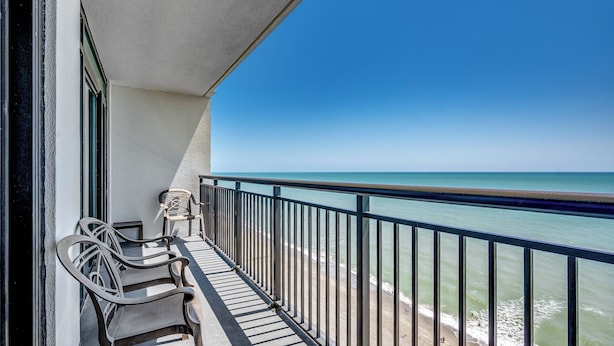 A balcony with two chairs, a railing, and a view of the ocean. - 🏖️Large Oceanfront~Lazy River~Awesome Amenities~ Caribbean Resort 1807🏖️ (Myrtle Beach)