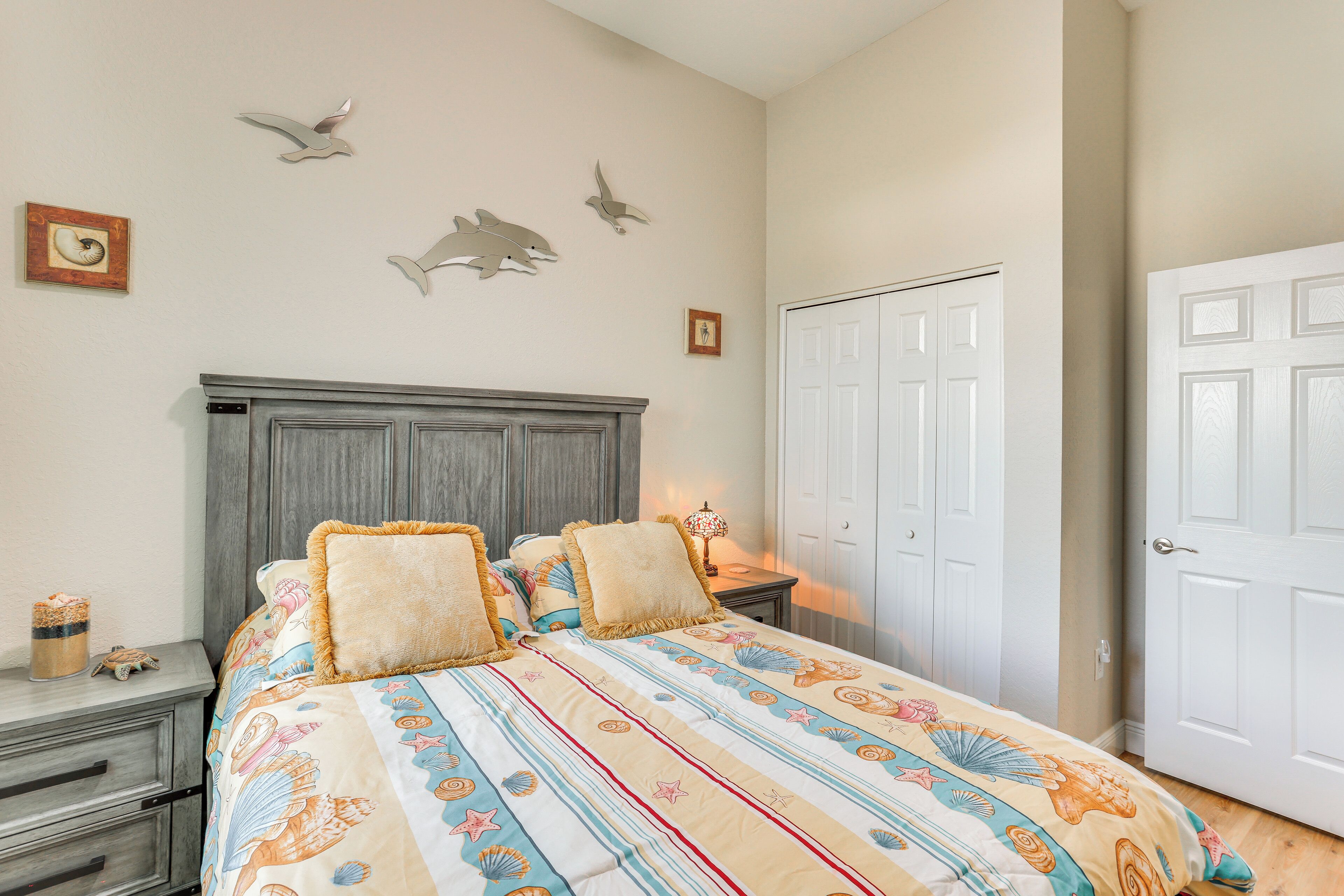 A bedroom with a bed, nightstands, a dresser, and a door.