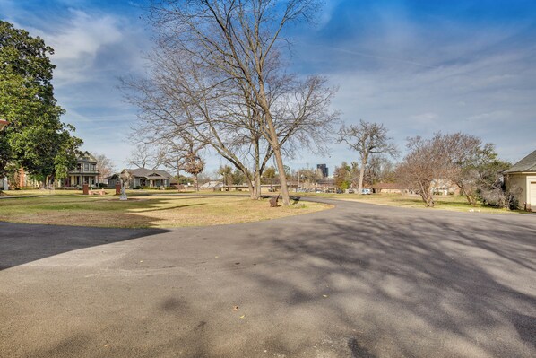 A residential street with houses, a park, and a large tree. - Historic Charnwood Guest House- 1 Mile to Downtown (Tyler)