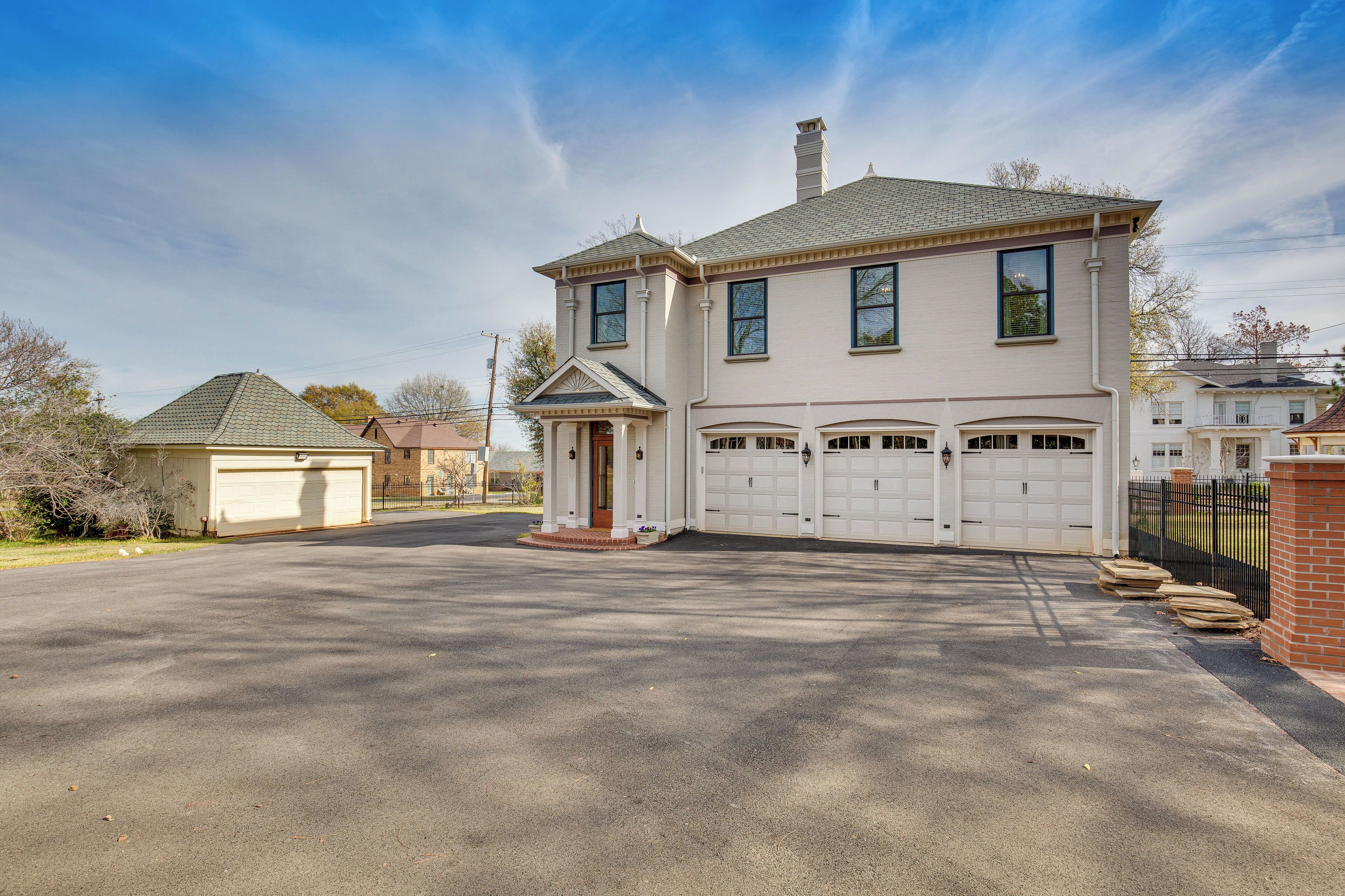 A two-story house with a garage, a driveway, and a small porch.