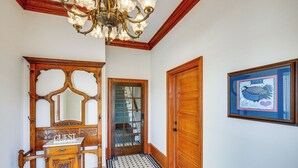 A hallway with a wooden bench, a mirror, a framed picture, and a door. - Historic Charnwood Guest House- 1 Mile to Downtown (Tyler)
