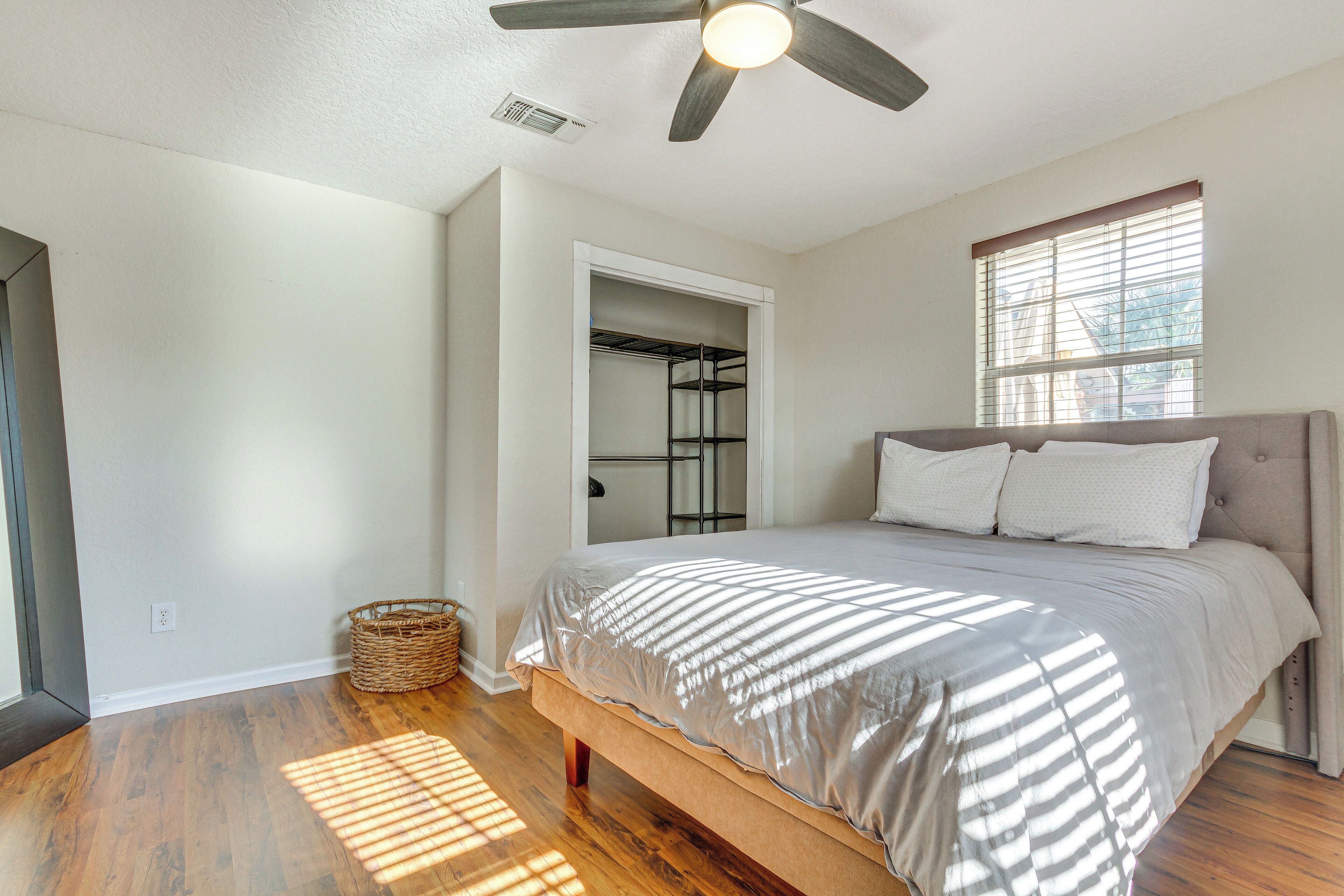 A bedroom with a bed, a ceiling fan, a window, and a closet.