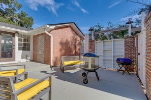 A backyard with a patio, a barbecue grill, a bench, and a pergola. - Pensacola Home in Historic East Hill Neighborhood (Pensacola)