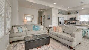 A modern living room with a sectional sofa, ottomans, and a ceiling fan. - Crystal Beach Home w/ Covered Patio: Pets Welcome! (Port Bolivar)