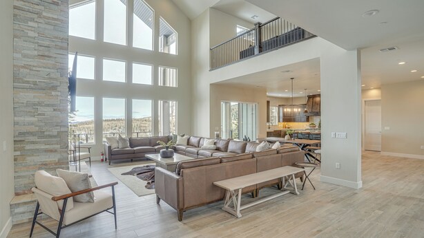 A spacious living area with a large sectional sofa, a bench, and a stone accent wall. - Spacious Utah Escape w/ Balcony & Mountain Views! (Brian Head)