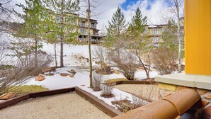 A snow-covered outdoor area with trees and a stone pathway. - Ski-in/ski-out Park City Studio w/ Pool Access! (Park City)
