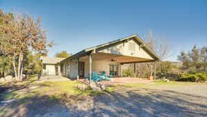 A single-story house with a covered porch, a front door, and a small patio area with outdoor seating. - Bright + Cozy Mariposa Getaway: 46 Mi to Yosemite! (Mariposa)