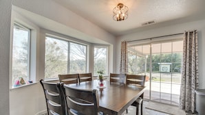 A dining area with a large wooden table, six chairs, and a vase with flowers. - Bright + Cozy Mariposa Getaway: 46 Mi to Yosemite! (Mariposa)
