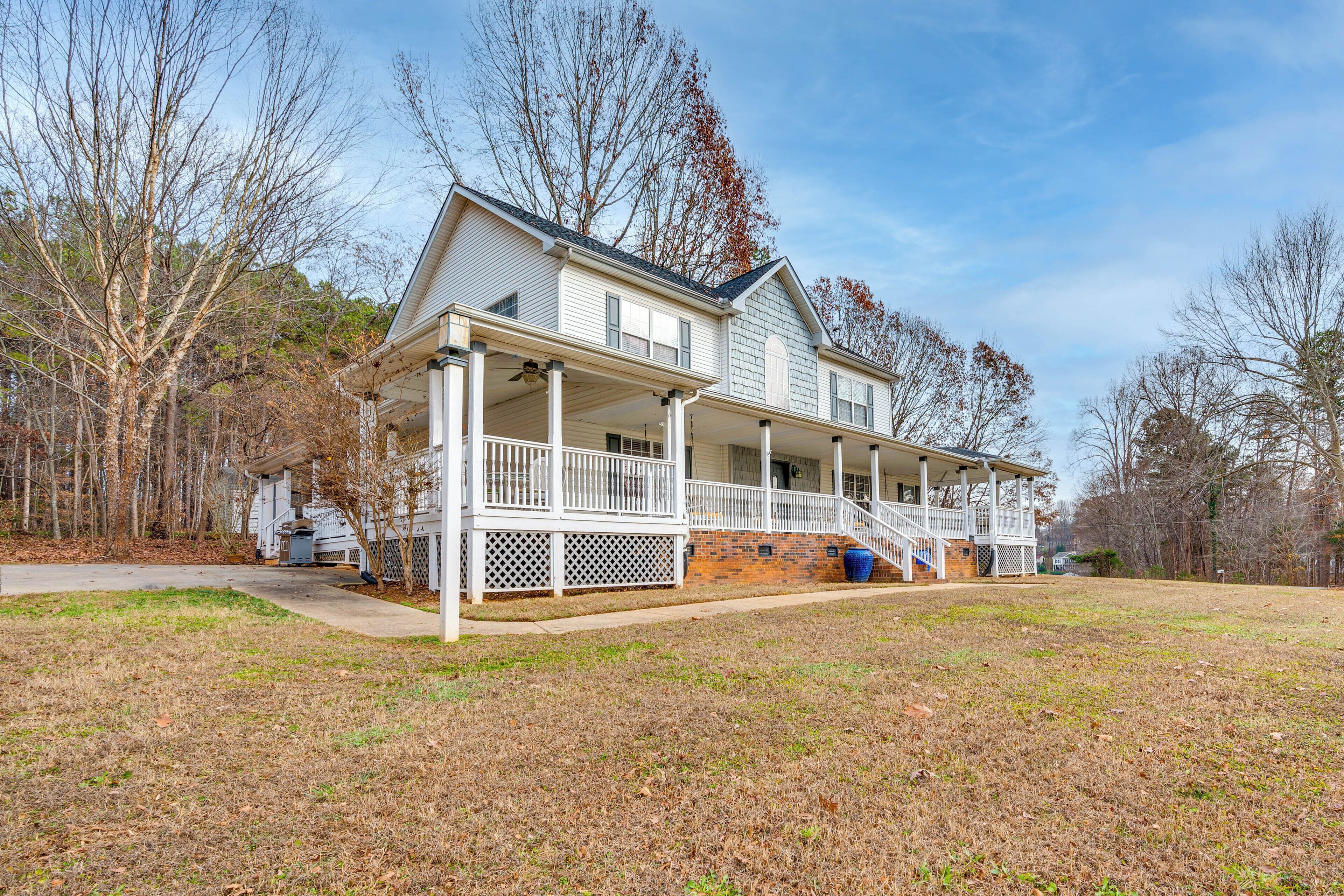A two-story house with a covered porch and a brick foundation.