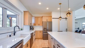 A modern kitchen with wooden cabinets, stainless steel appliances, and pendant lighting. - Great for Groups! Luxury Mtn-view Granby Home (Granby)