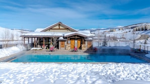A hotel with a pool surrounded by snow, wooden exterior, and a view of mountains. - Great for Groups! Luxury Mtn-view Granby Home (Granby)