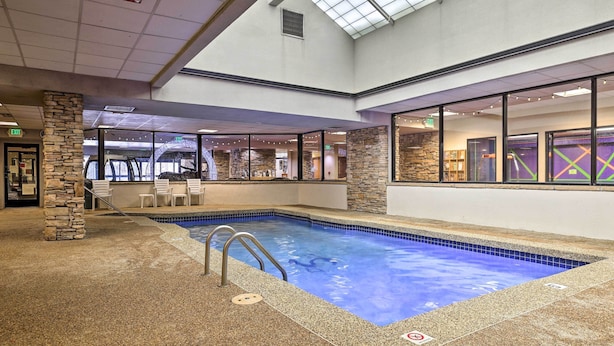 An indoor swimming pool with a stone pillar and a glass wall. - Easy Ski Shuttle Access! Winter Park Mtn Getaway (Winter Park)
