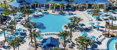 Ett semesterhotell med en stor pool i mitten, flera avkopplande områden med parasoller och palmer.