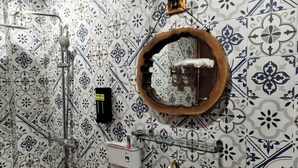 A bathroom with patterned tiles, a shower, a sink, and a soap dish. - Moc An by Bay Hotel (Hanoi)