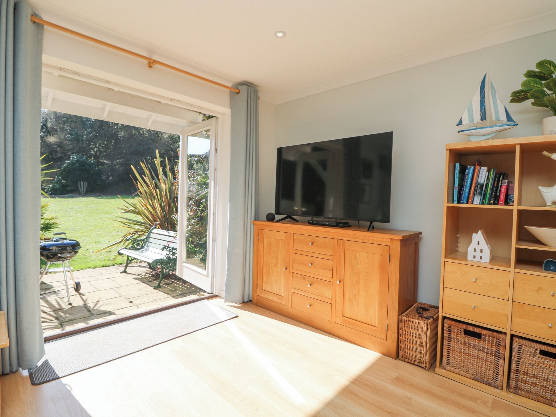 Ein Wohnzimmer mit Fernseher, Holzschrank und Bücherregal.