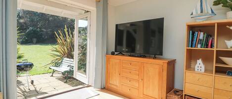 Ein Wohnzimmer mit Fernseher, Holzschrank und Bücherregal.