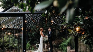 A couple holding hands in a greenhouse with stone flooring and string lights. - Luxury Treetop Escape with a Garden glasshouse (Kalorama)