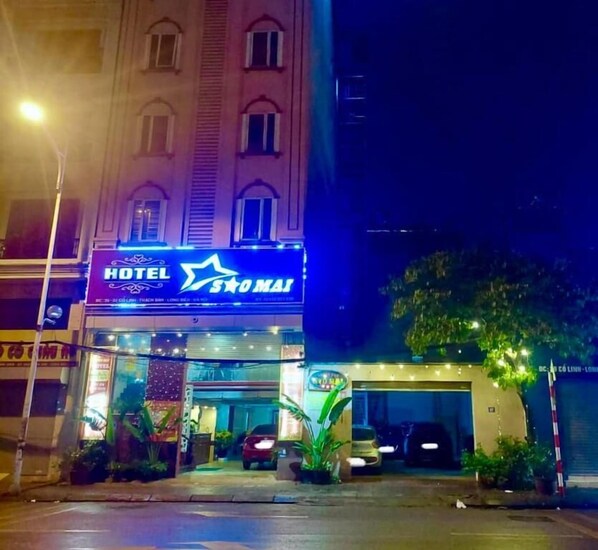 A hotel with a prominent sign, a covered entrance, and a parking area. - Sao Mai Hotel by Bay Luxury (Hanoi)