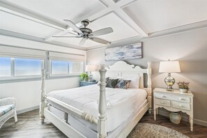 Relax in a classic bedroom with a four-poster bed, ceiling fan, and a cozy reading nook.