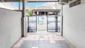 Uma entrada com portão para um edifício, piso de azulejos e portão de metal.