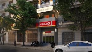 Un edificio de varios pisos con balcones y un letrero que dice "LA BELLE MAISON".