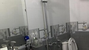 A bathroom with a white marble sink, a toilet, and a shower. - Anh Sao Hotel by Bay Luxury (Hanoi)