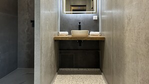 A modern bathroom with a rectangular mirror, a white sink, and a towel rack. - Hôtel Casa Matteu (Afa)