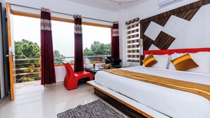 A modern hotel room with a large bed, a balcony with red curtains, a red chair, and a view of greenery. - Saalak Lite Eliot Exotica  (Dharamshala)