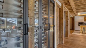 Un interior moderno con vigas de madera, una bodega de vino y una zona de cocina.