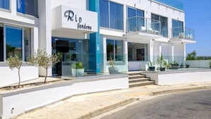 A modern building with a sign reading "Rio Gardens". - Rio Gardens Aparthotel (Ayia Napa)