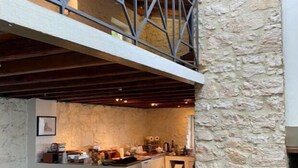 Un comedor rústico con pared de piedra y muebles de madera.