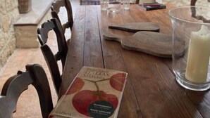 Un comedor rústico con una mesa de madera, sillas y un libro titulado 