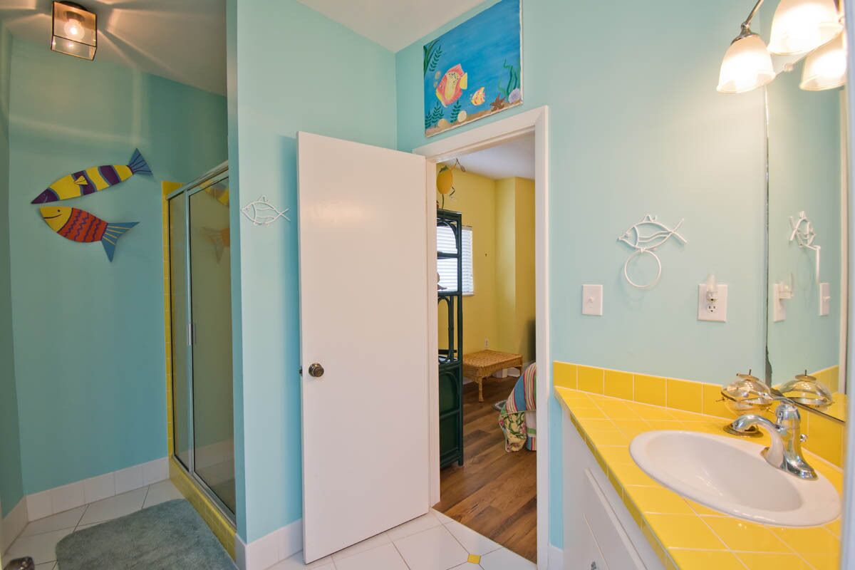 A bathroom with a shower, a sink, and a mirror.
