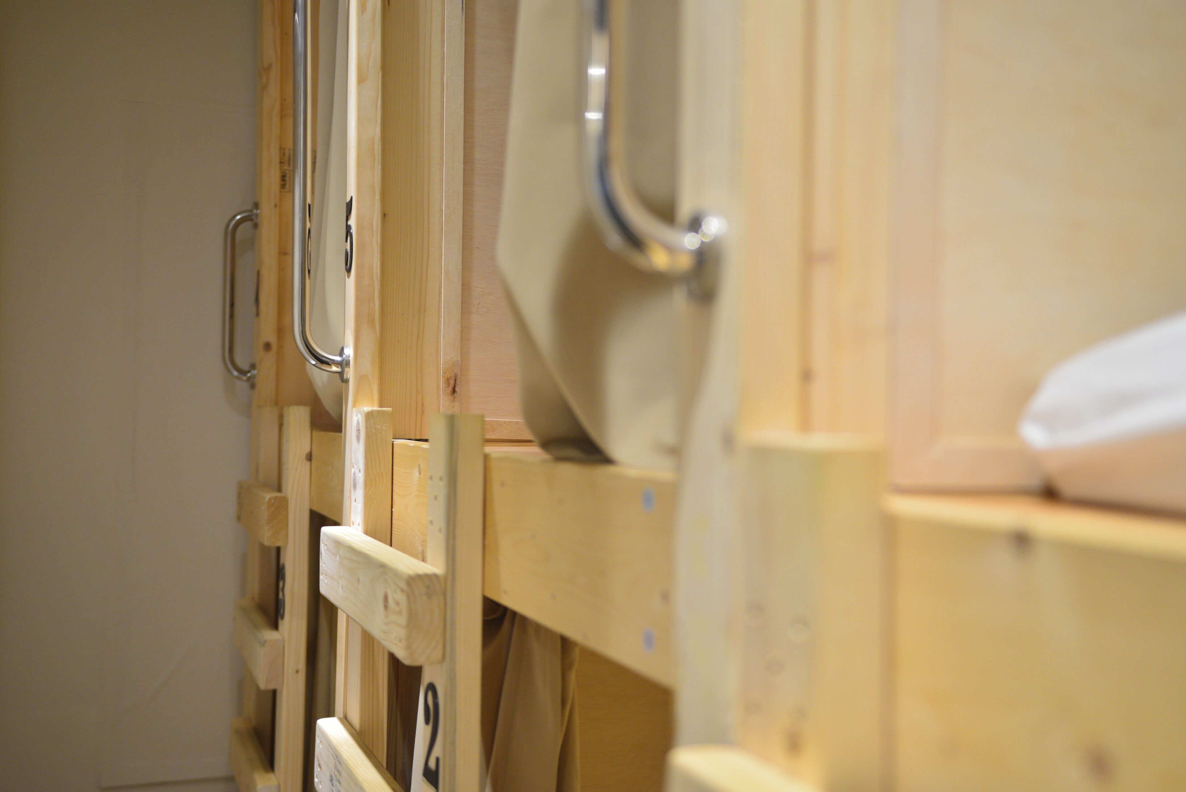 A wooden bunk bed with metal fixtures, likely in a hotel or hostel setting.