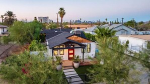 A modern house with a red door, surrounded by greenery, and a clear sky. - Downtown Phoenix Modern Retreat | 2 Homes in 1! (Phoenix)