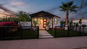 A modern house with a well-maintained lawn, a gated entrance, and a pathway leading to the front door. - Downtown Phoenix Modern Retreat | 2 Homes in 1! (Phoenix)