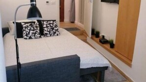 A bedroom with a bed, bedside table, lamp, TV, and a wardrobe. - Apartment AD - Pirovac (Pirovac)