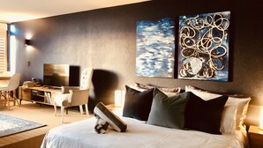 Ein modernes Schlafzimmer mit einem großen Bett, einem Schreibtisch und einem Fernseher.