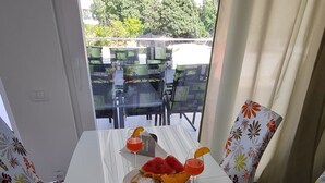A dining table with a magazine, a plate with food, and drinks. - Luxury Apartment Ani II (Sutivan)