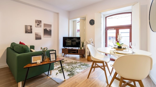 Relax in this stylish living room with a sofa, flat-screen TV, and dining area.