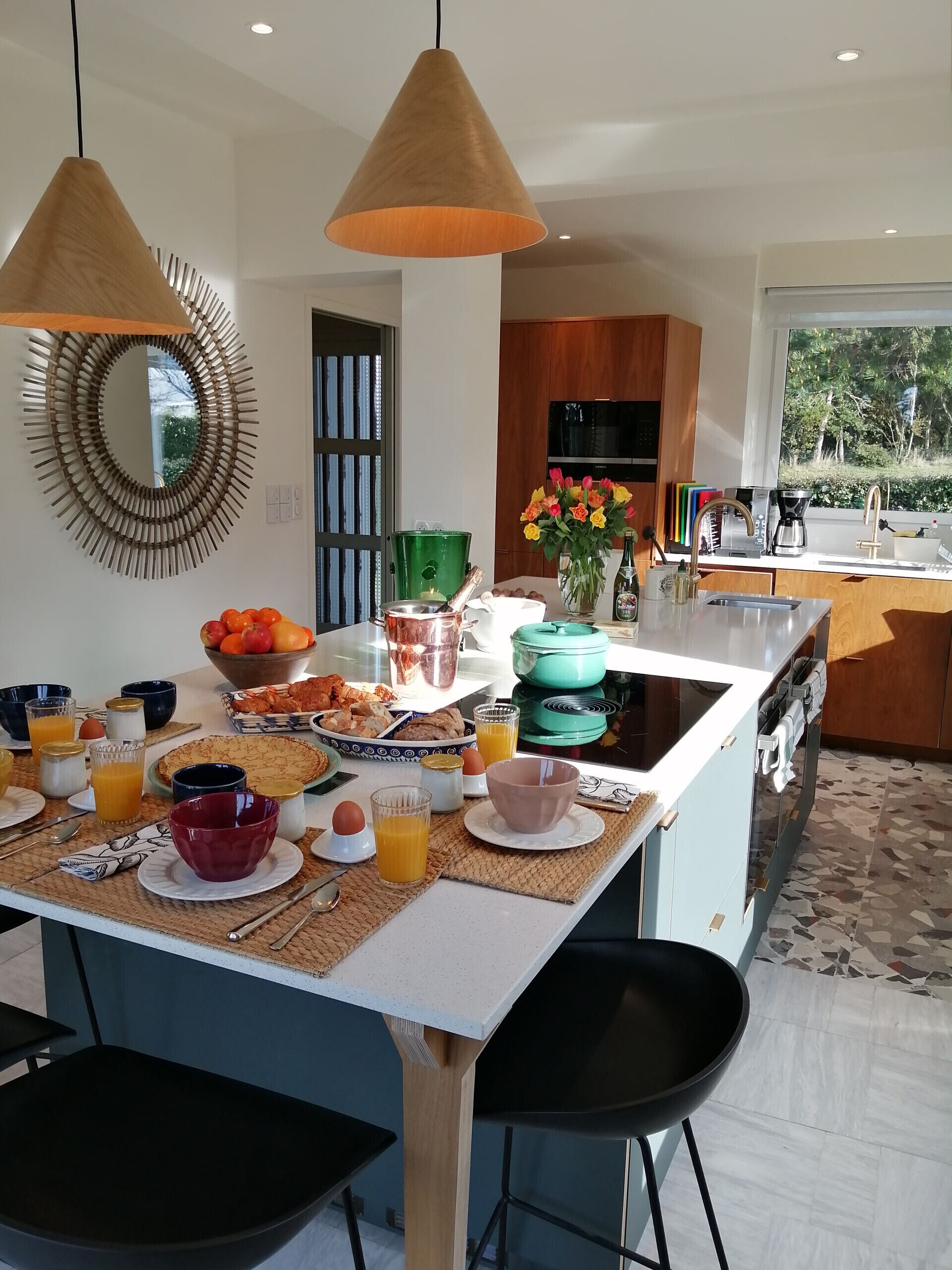 Een moderne keuken met een centraal eiland, een eethoek en uitzicht op de omgeving.