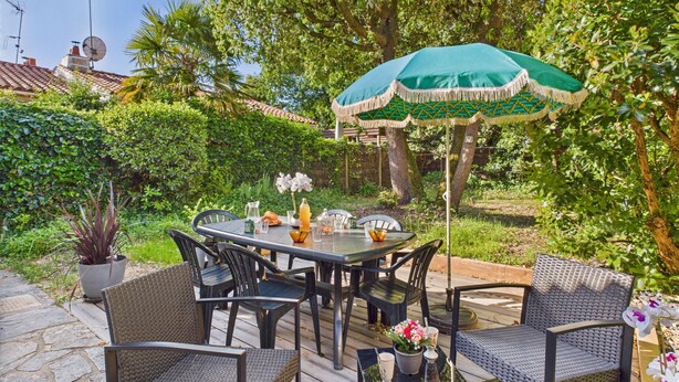 An outdoor patio with a round table, chairs, and a green umbrella. - House for 5 - 300m from Tanchet beach (Les Sables-d´Olonne)