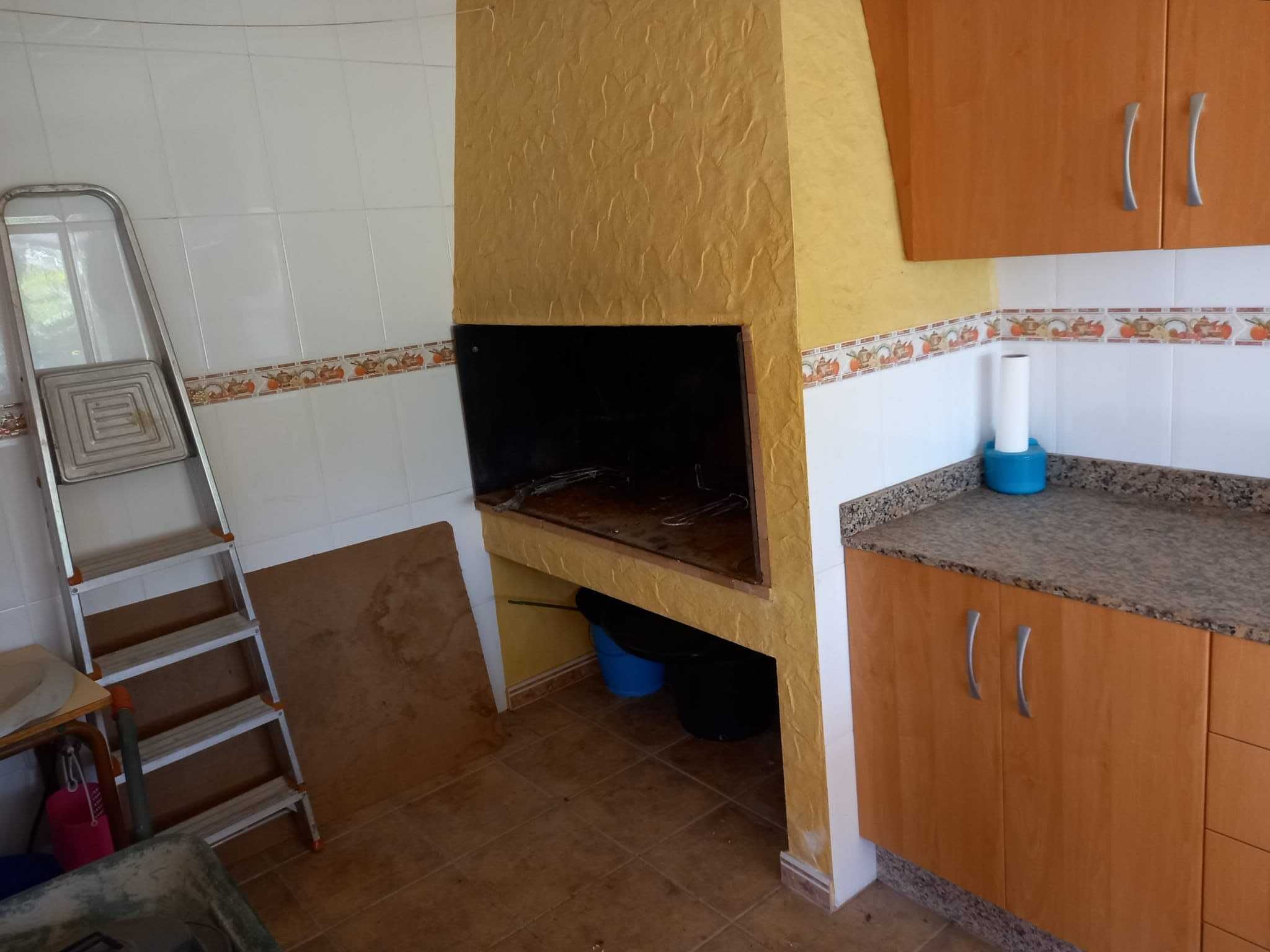 Une cuisine avec des meubles en bois, un dosseret carrelé et un four encastré.